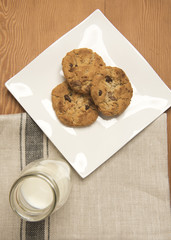 Chocolate chip cookies with a small glass bottle of milk 