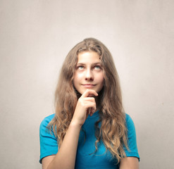 Naklejka premium Cute young girl thinking and looking up