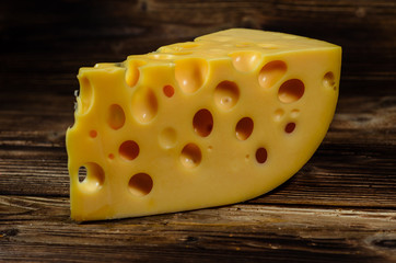 Piece of cheese on wooden table