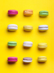 Sweet colorful macaroons on yellow background