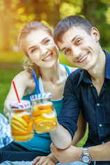 Happy boy and girl drink detox water with orange and lemon. The