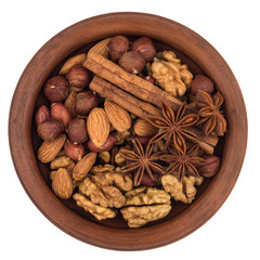 Mixture of nuts in a brown plate. Isolated on white background.