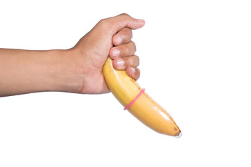Condom on banana in hand on white background