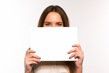 The girl is holding a sheet of blank paper in front of her