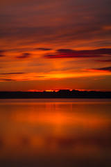 Orange and red sunset at coast of the lake