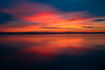 Orange and red sunset at coast of the lake