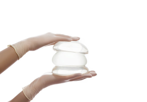 A set of different silicone breast implants on hands