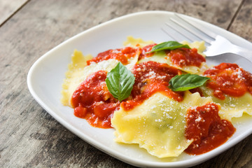 Ravioli with tomato sauce and basil on wooden table
