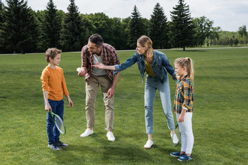 Obraz premium parents teaching little kids how to play badminton outdoors