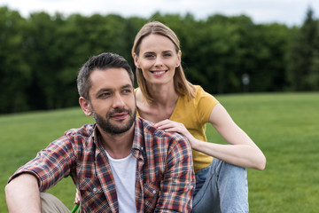 happy caucasian couple spending time together and relaxing on grass