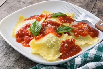 Ravioli with tomato sauce and basil on wooden table
