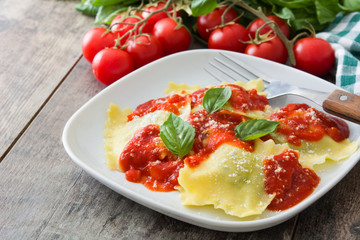 Ravioli with tomato sauce and basil on wooden table
