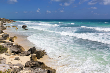 View to the sea on a rocky shore of the Caribbean sea. Sunny summer day. Turquoise water with big waves.