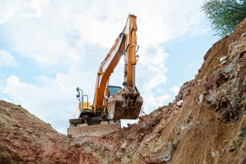 Excavator digging a trench. Work on the construction site.