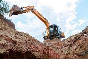 Excavator digging a trench. Work on the construction site.