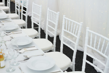fancy table set for a wedding dinner, white chairs