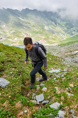 Naklejka na ściany i meble Young hiker with backpack on a trail