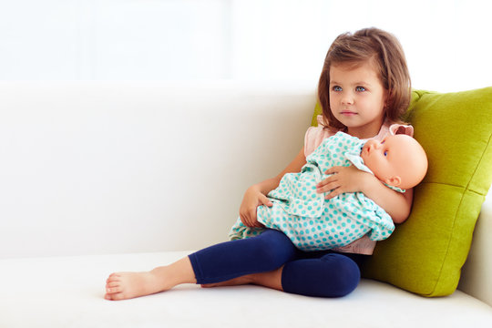 Adorable Little Baby Girl Lulling Doll On Hands