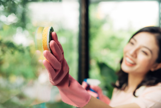 Cleaning Concept. Cheerful Asian Woman Cleaning Window.