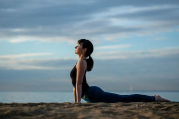 Fototapeta na wymiar Yoga asana outdoors on beach. up facing dog pose