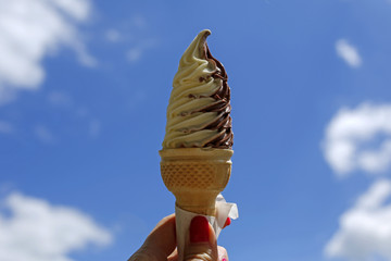 ice cream cone held up to the summer sky