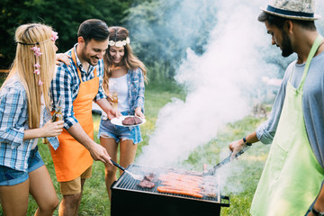 Obraz premium Friends spending time in nature and having barbecue