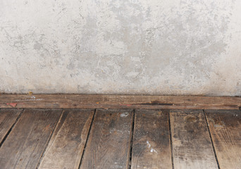 Old wooden floor and scuffed concrete wall