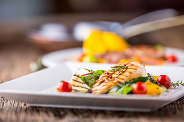Grill chicken breast. Grilled vegetables with chicken breast. Grilled chicken with vegetables on oak table.