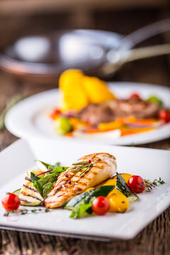 Grill chicken breast. Grilled vegetables with chicken breast. Grilled chicken with vegetables on oak table.