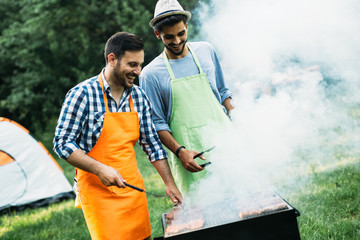 Friends spending time in nature and having barbecue