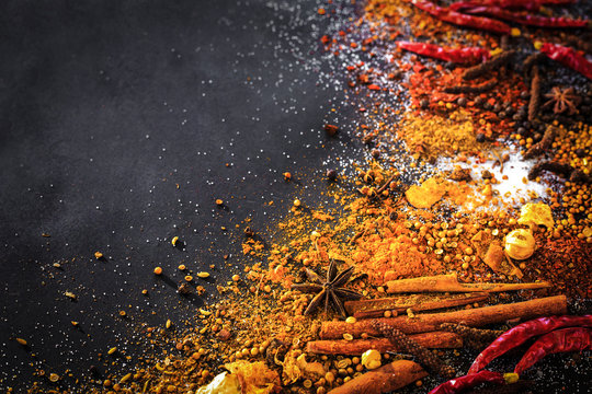 Variety Spices and herbs on black stone background, Top view with empty space background for texture. Italian food, eastern food concept.