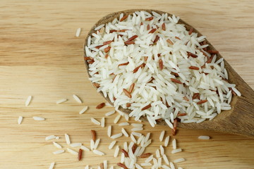 Thai white jasmine rice mixed with brown rice in wooden ladle
