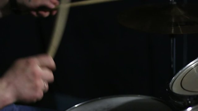 Drummer playing on drum kit.