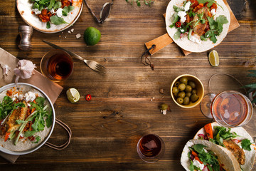 Tacos with fried avocados , tomatoes and greens on distressed wooden background. Served with beer, lime and olives. Mexican cuisine interpretation. Horizontal composition with copy space.