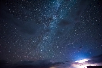 Fototapeta na wymiar Night sky during thunderstorm in the distance with milky way and stars