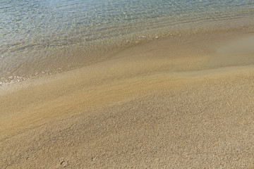 Fototapeta na wymiar Soft sea wave on sandy beach, Beautiful Greek beach with fine sand, Close up photo of sandy beach with soft wave in motion