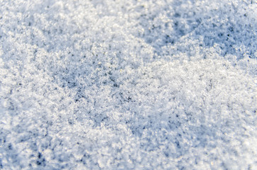 Macro closeup of heavy layer of snow ice crystals showing detail and texture on ground in winter