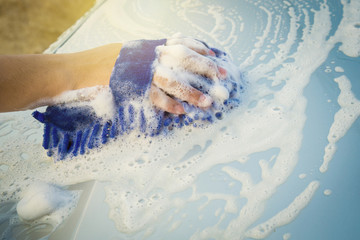 Fototapeta na wymiar Hands hold blue sponge for washing car.