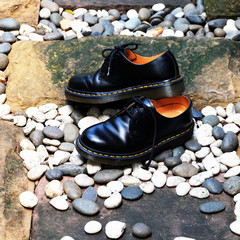 Black leather shoes on stones floor texture