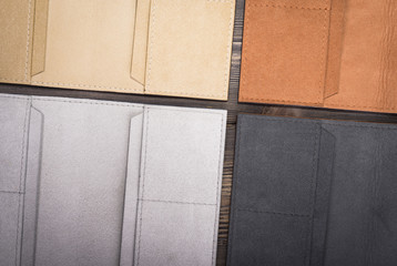 Four different collors stitched wallets texture on rustic wood background