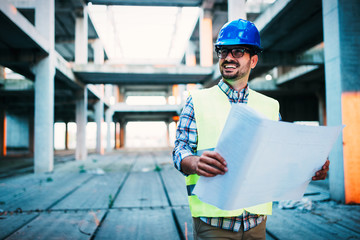Picture of construction site engineer looking at plan