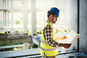 Picture of construction site engineer looking at plan