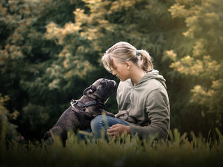 The girl talks to the dog. Nature, green grass, beautiful