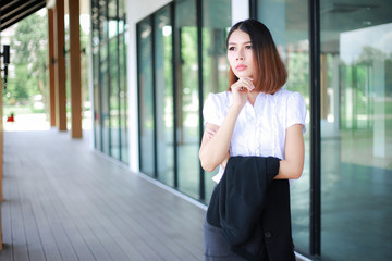 Fototapeta premium Modern business women casual outfits in the office with copy space, Business woman standing cross one's arm, Asian people young beautiful businesswoman smile. business concept