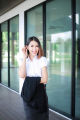 Fototapeta premium Modern business women casual outfits in the office with copy space, Business woman standing cross one's arm, Asian people young beautiful businesswoman smile. business concept