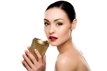 Sensual young woman holding golden paper cup and looking at camera isolated on white
