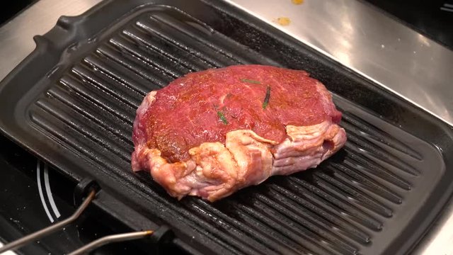 Closeup of steak frying on the grill
