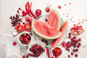 Red fruit and vegetable composition on linen fabric. Summer natural beauty concept with copy space.