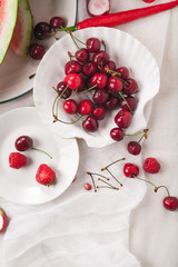 Red fruit and vegetable composition on linen fabric. Summer natural beauty concept with copy space. Vertical composition