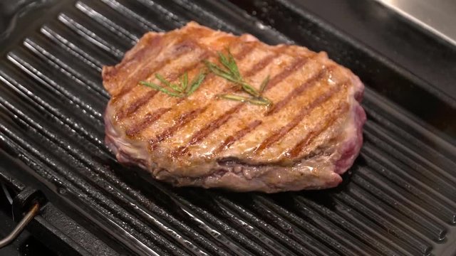 Closeup of tasty grilled steak on the grill pan